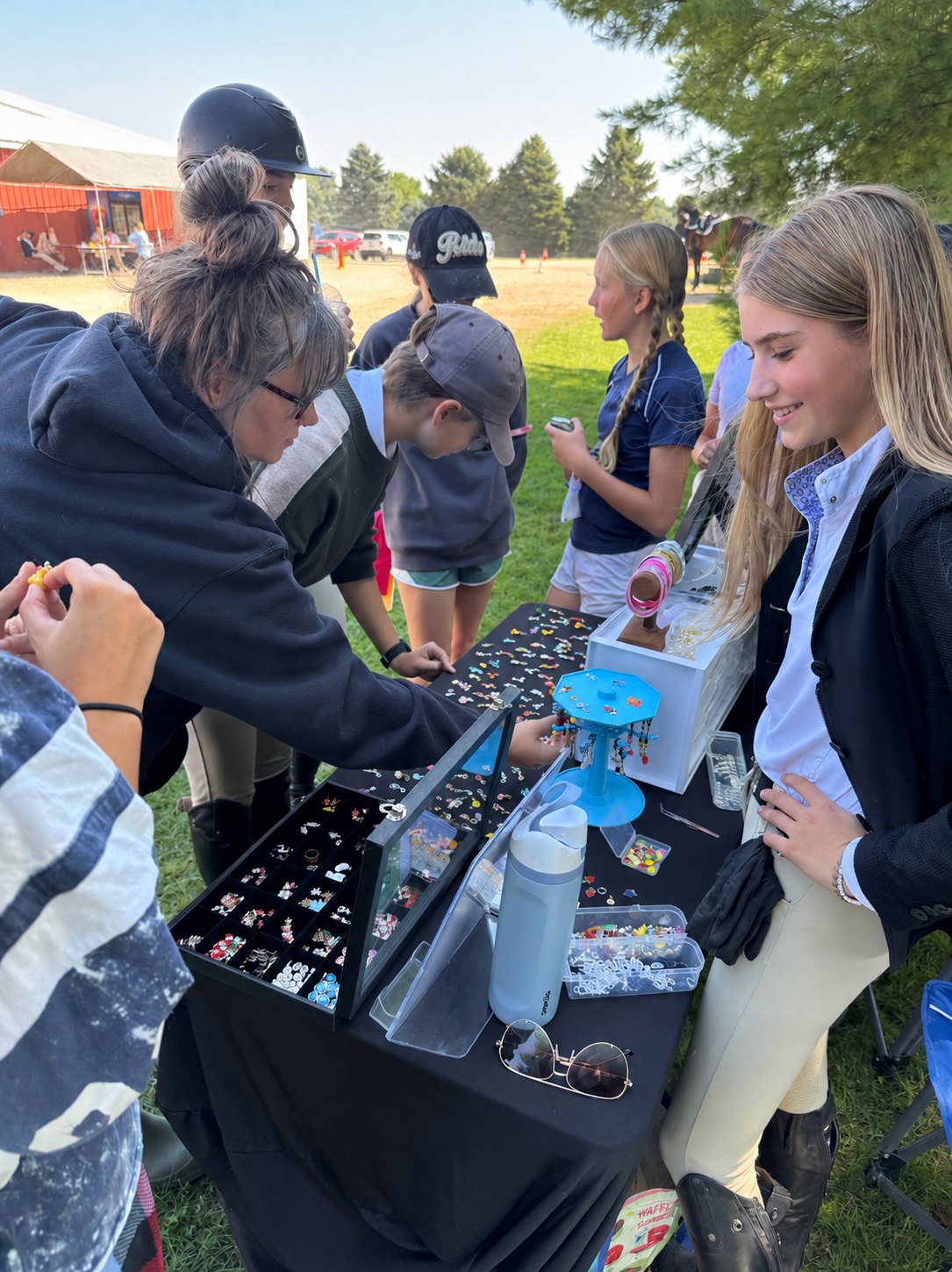 Customers gathered around the SO Equestrian charm display, picking out their favorites at a show